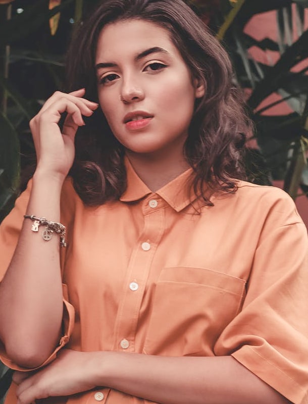 woman wearing a vivid tangerine buttoned shirt